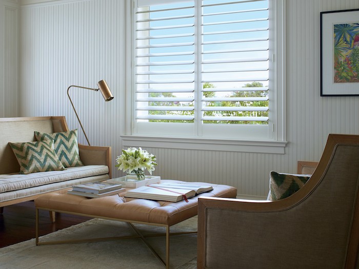 A living room with a brass lamp and a coffee table with brass legs.